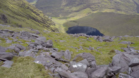 Tilt-up-shot-of-a-wonderful-lake-from-the-top-of-a-high-mountain-on-a-wonderful-day-in-Ireland-in-4K