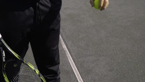 Ein-Tennisspieler-Steht-Kurz-Vor-Dem-Aufschlag-Und-Lässt-Den-Ball-Auf-Dem-Kiesboden-Hüpfen,-Während-Er-Sich-Fertig-Macht
