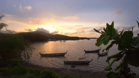 Angeln-Mit-Longtail-Booten,-Die-In-Der-Bucht-Auf-Dem-Meer-In-Thailand-Vor-Anker-Liegen,-Mit-Einem-Goldenen-Sonnenuntergang-In-Zeitlupe