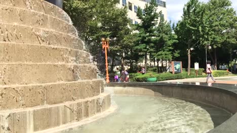Water-falls-from-a-fountain-in-slow-motion-at-Sun-and-Moon-Plaza,-Mokong,-Yangcheon-gu,-Seoul,-South-Korea