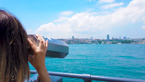 Slow-motion:beautiful-girl-looks-through-sightseeing-binoculars-on-Bosphorus,a-popular-destination-in-Uskudar,Istanbul,Turkey