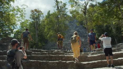 Slow-motion-of-people-walking-up-the-stairs-at-the-Muyil-archeologica-site,-Quintana-Roo,-Mexico