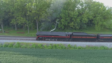 An-Aerial-View-of-a-Steam-Train-no-611-Puffing-Smoke-Through-Farm-Countryside-on-a-Sunny-Summer-Day-with-Green-Fields