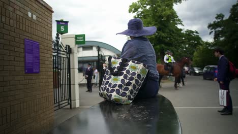 Wimbledon-2019:-tourist-with-a-typical-summer-British-hat-waiting-to-get-inside-the-centre-court-with-police-on-horses-in-front-of-the-gates