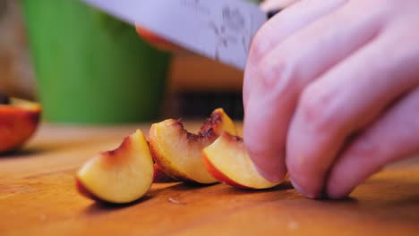 the-cook-cuts-the-nectarine-on-a-wooden-board