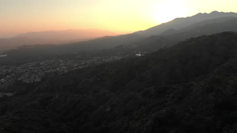 Aerial-of-Orange-Sunset-Behind-Mountain
