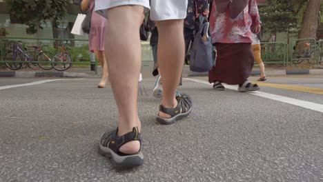 Lower-view-of-the-man-wearing-short-and-adventure-sport-sandal-while-walking-on-the-pathway-in-singapore-area-in-daytime
