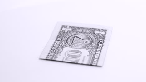 Ein-Dollar-Dreht-Sich-Auf-Weißem-Hintergrund-Im-Fotostudio-In-Schwarzweiß