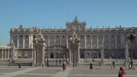 Frontalansicht-Des-Königspalastes-Von-Madrid-Mit-Touristen,-Die-Spazieren-Gehen-Und-Fotos-Machen