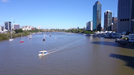 Aerial-shot-of-City-Ferry-with-tall-city-buildings-along-river-Brisbane,-Queensland