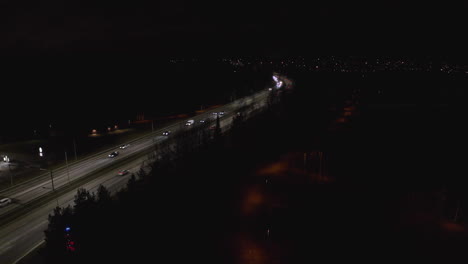 Cars-driving-at-night-on-illuminated-highway