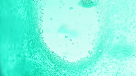 Makroaufnahme-Von-Strahlend-Blauem-Wasser-Mit-Vielen-Glitzernden-Blasen,-Die-Einen-Kleinen-Fleck-Ohne-Blasen-Hinterlassen