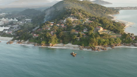 Drohnen-Luftaufnahme-Einer-Paradiesischen-Felsigen-Küste-Bei-Sonnenuntergang,-Jurere-Internacional,-Praia-Do-Forte,-Florianopolis,-Santa-Catarina,-Brasilien
