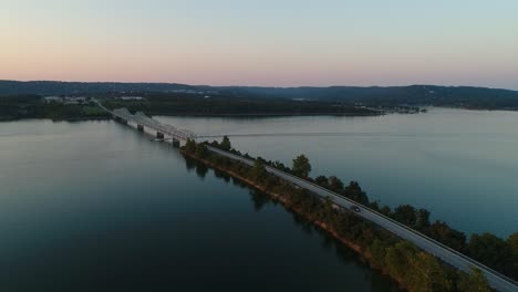 Aerial-view-of-a-bridge-at-Table-Rock-Lake-in-Missouri-with-a-boat-traveling-under-the-bridge