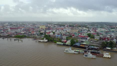 Suriname-River-flowing-through-Heritage-City-of-Paramaribo-in-Suriname,-aerial-view