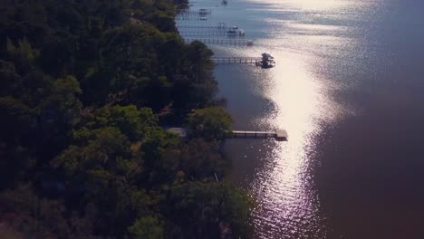 A-drone-dramatically-flies-along-he-shoreline-revealing-a-beautiful-house-on-the-water