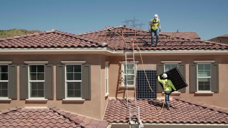 Trabajadores-Masculinos-Levantando-Paneles-Solares-En-La-Azotea-De-Una-Casa-Residencial-De-Azulejos