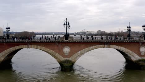 Napoleonische-Brücke-Pont-De-Pierre-In-Bordeaux,-Frankreich,-Mit-Menschen,-Die-Den-Fluss-Garonne-überqueren,-Kamerafahrt-Mit-Dem-Dolly-Rechts-Aus-Der-Luft