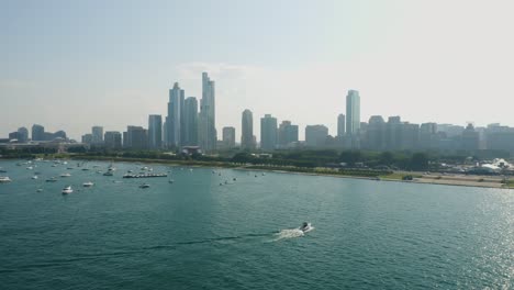 Luftstoß-In-Richtung-Chicagos-Grant-Park,-Während-Ein-Boot-Durch-Den-Rahmen-Fährt