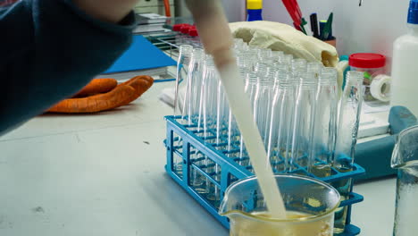 Time-lapse-of-laboratory-technician-filling-vials-with-a-yellow-solution