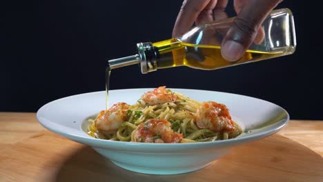 Slider-Shot-of-Extra-Virgin-Olive-Oil-Being-Drizzled-Over-a-Shrimp-and-Pasta-Dish