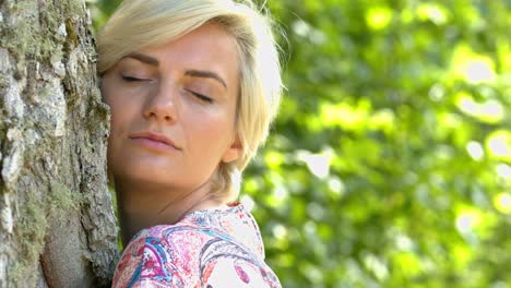 Beautiful-Blonde-Woman-Hugging-The-Tree-and-Enjoy-The-Sunny-Day---Close-Up-Shot
