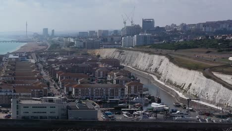 Aufsteigende-Einspielaufnahme-Des-Yachthafens-Von-Brighton,-Der-Apartments-–-Der-Strand-Mit-Der-Stadt,-Dem-Pier-–-I360-Im-Hintergrund