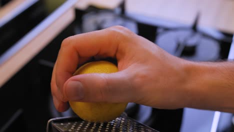 the-cook-rubs-a-lemon-on-a-grater