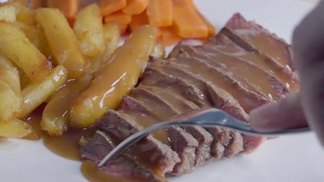 Close-Slow-Motion-Slider-Shot-of-Eating-Steak-and-Fries-With-a-Fork