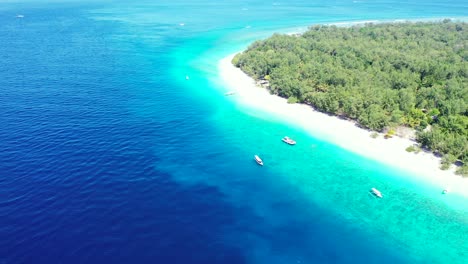Wunderschöne-Tropische-Insel-Mit-üppiger-Vegetation-Und-Weißem-Sandstrand,-Touristen-Kommen-Mit-Booten-An-Land-Und-Segeln-über-Die-Blau-türkisfarbene-Lagune,-Indonesien