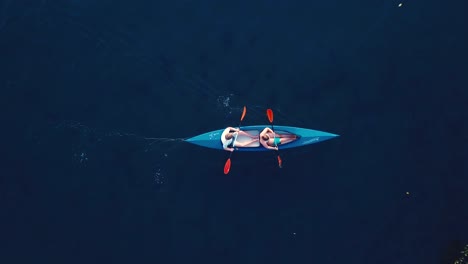 drone-shot-of-a-couple-in-a-kayak-on-the-ocean-going-from-left-to-right-with-no-land-in-sight