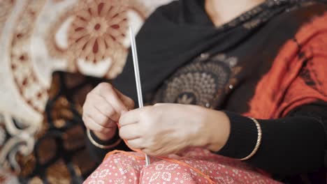 Traditional-Indian-woman-start-knitting-with-red-thread-and-needle-craft