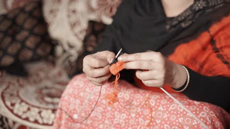 Woman's-hands-knits-with-craft-needles-and-red-and-black-thread