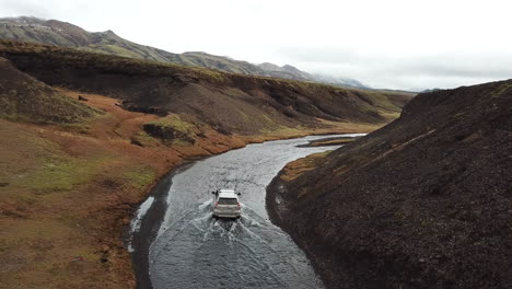 Vierrädriges-Fahrzeug-In-Extremem-Zustand,-Das-Sich-über-Seichtes-Wasser-Im-Ländlichen-Island-Bewegt-Und-Die-Luftaufnahme-Verfolgt