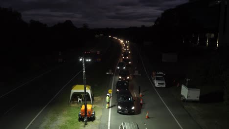 Long-Queue-Of-Cars-Waiting-To-Cross-The-Gold-Coast-Border---Traffic-At-State-Border-Checkpoint---Coronavirus-Pandemic-Restrictions---wide-shot