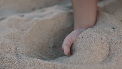 A-child-takes-sand-in-his-hand-and-lets-it-run-between-his-fingers
