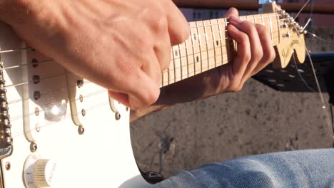 Close-up-of-young-guitar-player-playing-electrical-guitar-on-open-air-concert-on-the-day-of-music