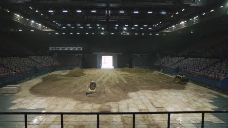 Shaping-dirt-inside-indoor-stadium-in-preparation-for-a-supercross-event