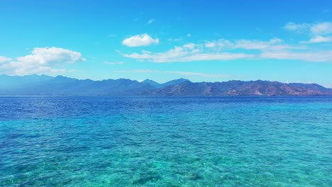 Océano-Azul-Tranquilo-Con-Cielo-Azul-Nublado-Arriba,-Isla-Mare,-Indonesia---Toma-Aérea