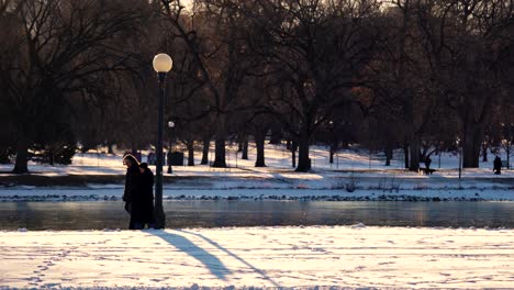 Old-couple-walking-in-park-against-a-background-of-warm-light