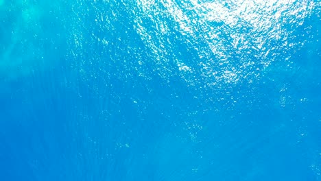Wunderschöne-Abstrakte-Blaue-Meeresstruktur-Mit-Klarem,-Lebendigem-Wasser,-Das-Sonnenlicht-An-Einem-Heißen-Sommertag-In-Der-Karibik-Reflektiert