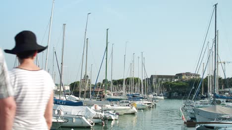 vacationing-tourists-walking-across-marina-where-sailboats-are-stationed