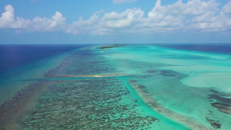 Friedliche-Türkisfarbene-Lagune-Mit-Korallenriffen-Rund-Um-Das-Atoll-Und-Winzige-Tropische-Inseln-Unter-Gefrorenen-Weißen-Wolken-Auf-Den-Malediven