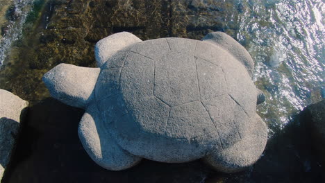 A-beautiful-wide-shot-of-a-turtle-stone-statue-in-the-middle-of-Kamo-River-at-Kyoto,-Japan-on-sunny-day