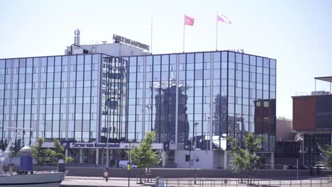 An-Einem-Strahlend-Sonnigen-Tag-Wehen-Fahnen-Auf-Dem-Dach-Des-Gebäudes-Der-Handelskammer-In-Amsterdam,-Niederlande