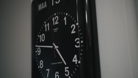 A-black-wall-clock-displayed-to-tell-time---Close-up