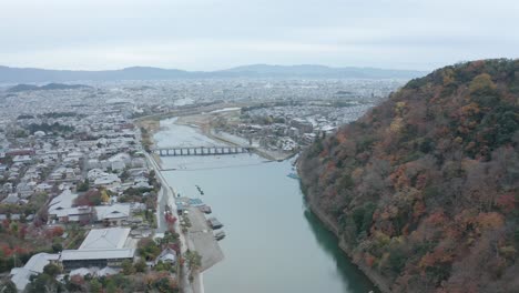 Togetsu-Kyo-Bridge-in-Arashiyama,-Kyoto,-Aerial-Pullback-shot-in-Autumn