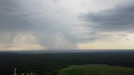 Luftaufnahme-Entfernter-Großer-Dunkelblauer-Sturmwolken,-Die-Sich-Im-Sommer-Am-Horizont-Bilden,-Aufsteigende-Weitwinkel-Drohnenaufnahme