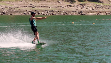 Man-Enjoying-The-Water-Ski-Gliding-With-Speed-On-Water-Surface-At-The-Lake-In-Albufeira-da-Barragem-Do-Ermal,-Portugal---Wide-Shot