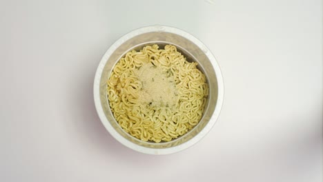 Preparing-a-quick-ramen-noodles-in-a-white-box,-plastic-cup